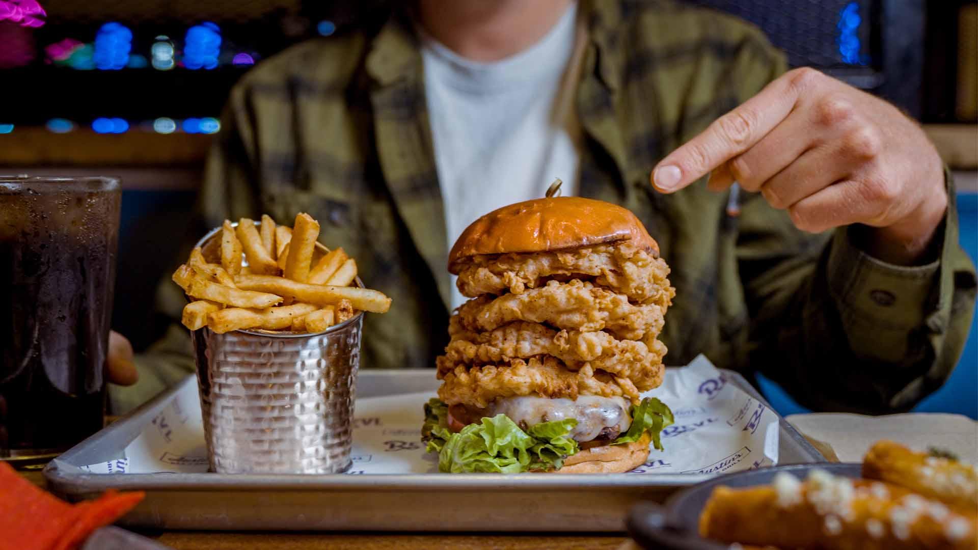 Man pointing a finger at a delicious burger